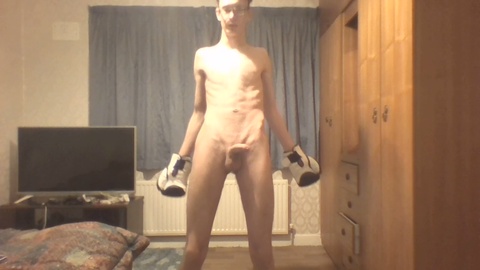 Slim guy in boxing gloves flaunts his ribcage while shadow boxing