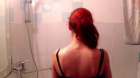 Seducente sessione in solitaria nella doccia di una giovane e affascinante rossa