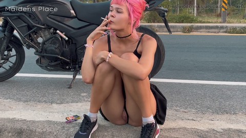 Novia en una motocicleta orinando junto a la carretera