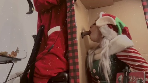 Santa stuffs his "north pole" through a Christmas gloryhole and plays with his Elf