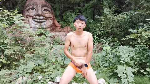 Apuesto joven chino disfruta de una placentera sesión en solitario en el pintoresco bosque.