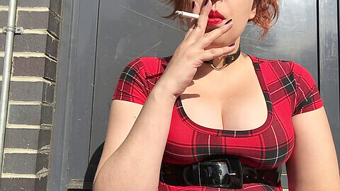 Jeune gothique sexy fume en robe écossaise écarlate et dévoile ses seins fermes