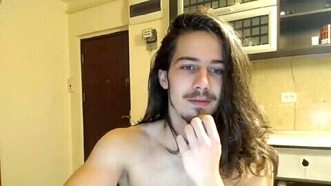 Ragazzo dai capelli lunghi si esibisce in webcam in una sessione solista intima