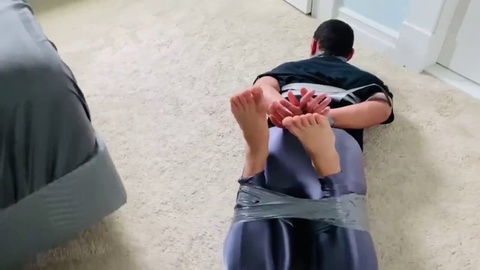 Hilfloser Kerl wird straff mit Klebeband gefesselt und geknebelt in einer echten Bondage-Session